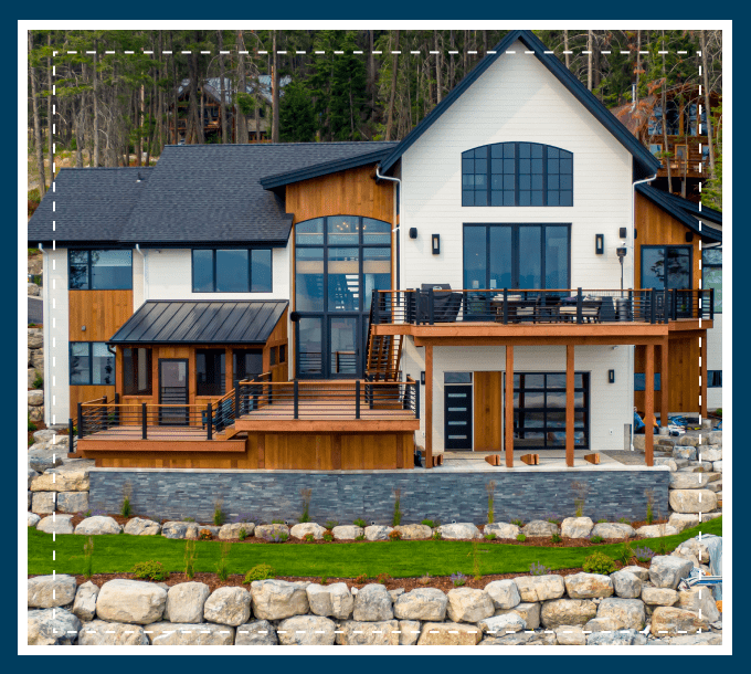 A large house with a stone wall and a rock garden.